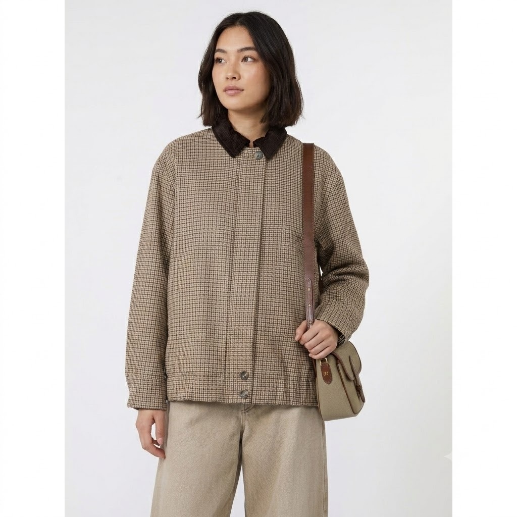 Eleva i tuoi look quotidiani con la giacca WKDFESTA Weekend Max Mara, un capospalla dallo stile intramontabile che fonde l'ispirazione country-chic britannica con la precisione sartoriale italiana. Questo modello si distingue per la sua raffinata micro-fantasia a quadri nei toni caldi del beige, del tortora e del testa di moro, interrotta elegantemente dal sofisticato colletto a contrasto in velluto a coste scuro.La silhouette contemporanea dal taglio boxy (squadrato) e leggermente oversize assicura una vestibilità rilassata e confortevole, ideale per creare impeccabili outfit a strati durante le mezze stagioni. Curata nei minimi dettagli, presenta una chiusura frontale con patta coperta per un design pulito ed essenziale, rifinito da bottoni a pressione a vista solo sul colletto e sul fondo.Caratteristiche Tecniche e Dettagli del ProdottoBrand: Weekend Max MaraModello: WKDFESTASilhouette: Linea boxy e dritta a taglio giubbotto, con spalle leggermente scese.Tessuto Principale: Texture strutturata a micro-quadri (effetto pied-de-poule / check).Dettaglio Iconico: Colletto a punta in morbido velluto marrone scuro.Chiusura: Bottoni automatici nascosti sotto la finta, con bottoni metallici a vista alle estremità.Dettagli Funzionali: Pratiche tasche laterali inserite nel filetto e polsini regolabili.