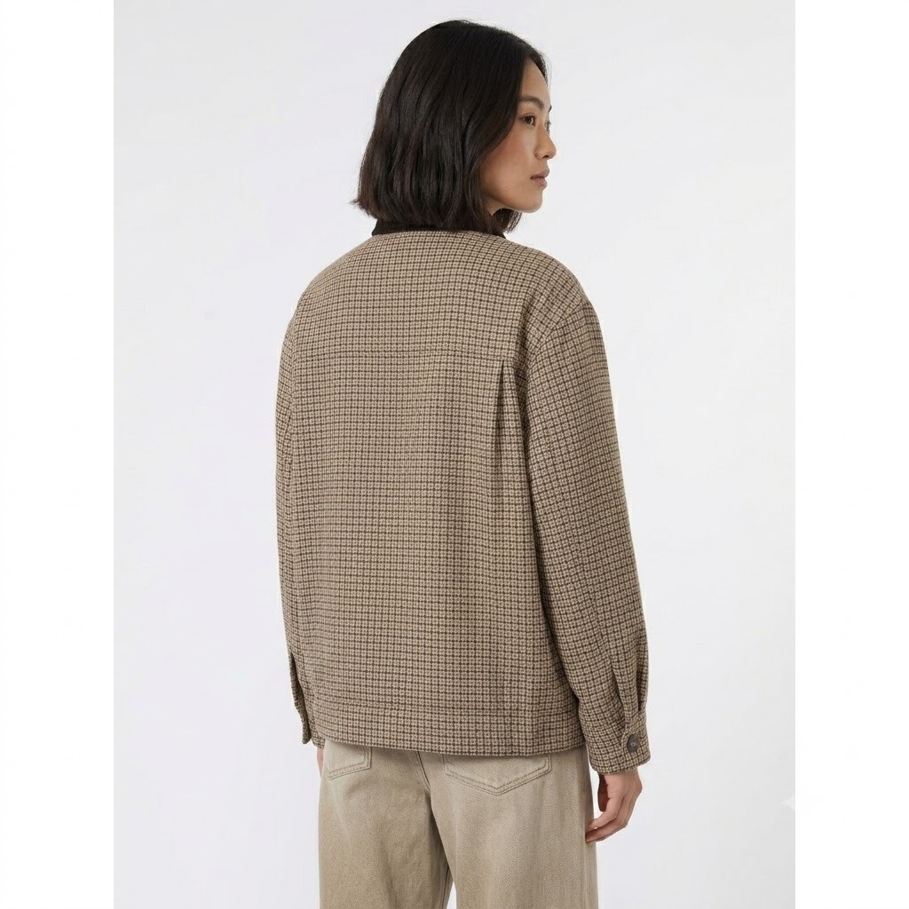 Eleva i tuoi look quotidiani con la giacca WKDFESTA Weekend Max Mara, un capospalla dallo stile intramontabile che fonde l'ispirazione country-chic britannica con la precisione sartoriale italiana. Questo modello si distingue per la sua raffinata micro-fantasia a quadri nei toni caldi del beige, del tortora e del testa di moro, interrotta elegantemente dal sofisticato colletto a contrasto in velluto a coste scuro.La silhouette contemporanea dal taglio boxy (squadrato) e leggermente oversize assicura una vestibilità rilassata e confortevole, ideale per creare impeccabili outfit a strati durante le mezze stagioni. Curata nei minimi dettagli, presenta una chiusura frontale con patta coperta per un design pulito ed essenziale, rifinito da bottoni a pressione a vista solo sul colletto e sul fondo.Caratteristiche Tecniche e Dettagli del ProdottoBrand: Weekend Max MaraModello: WKDFESTASilhouette: Linea boxy e dritta a taglio giubbotto, con spalle leggermente scese.Tessuto Principale: Texture strutturata a micro-quadri (effetto pied-de-poule / check).Dettaglio Iconico: Colletto a punta in morbido velluto marrone scuro.Chiusura: Bottoni automatici nascosti sotto la finta, con bottoni metallici a vista alle estremità.Dettagli Funzionali: Pratiche tasche laterali inserite nel filetto e polsini regolabili.